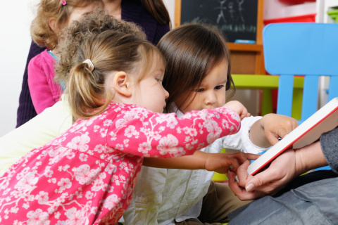 small children looking at a book