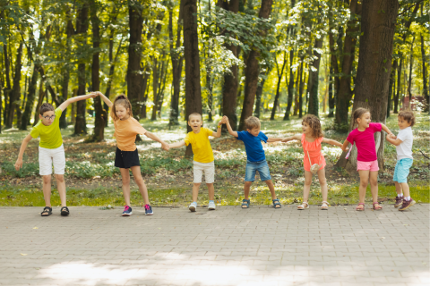 children holding hands and dancing outside