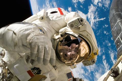 an astronaut on a spacewalk above earth