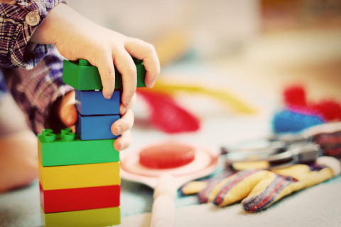 a child's hands putting primary colored blocks together