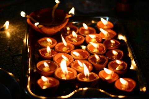 dimly lit photo of lit candles and a Diwali lantern