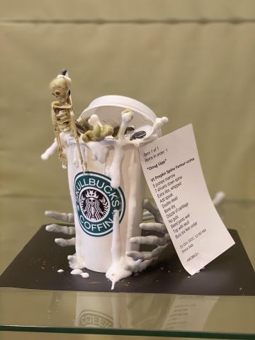 a mini skeleton inside a fake Starbucks cup labeled "Skullbucks Coffin"