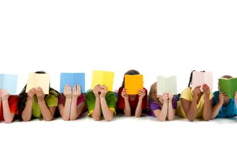 children laying down holding books in front of their faces