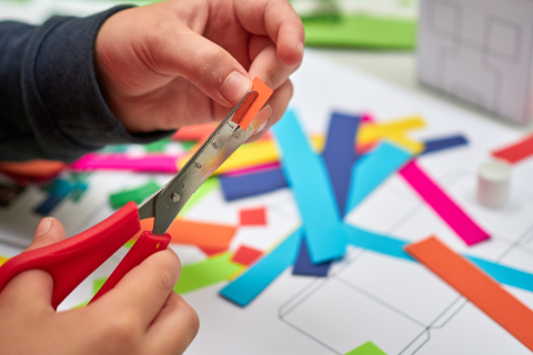 hands cutting colorful paper