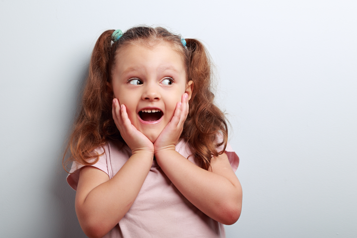 little girl with pigtails showing a surprised face