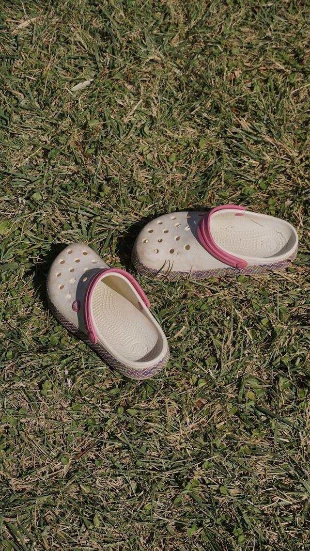 pair of white and pink crocs on grass