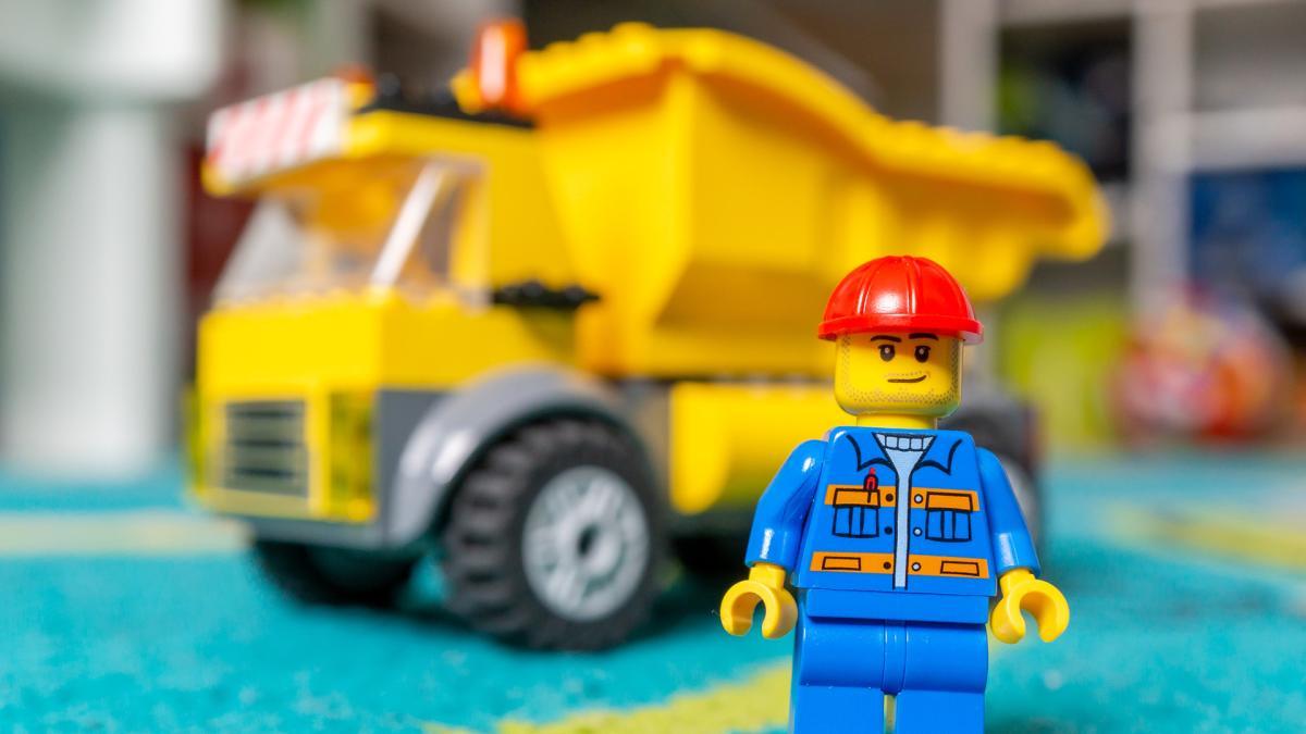 Lego minifig standing in front of a truck